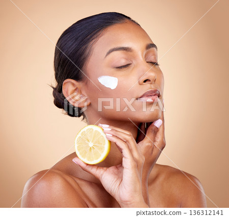 Woman, lemon and cream for beauty, natural skincare product and cosmetics or vitamin c benefits and thinking. Person sleeping with face lotion, fruits and skin dermatology on brown, studio background Woman, lemon and cream for beauty, natural skincare product and cosmetics or vitamin c benefits and thinking. Person sleeping with face lotion, fruits and skin dermatology on brown, studio background 136312141