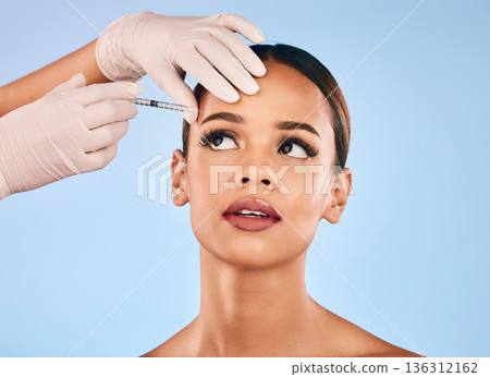 Eyebrow, injection and beauty, woman and cosmetic surgery and dermatology isolated on blue background. Face, skincare and syringe, female model and doctor hands with liquid collagen in studio Eyebrow, injection and beauty, woman and cosmetic surgery and dermatology isolated on blue background. Face, skincare and syringe, female model and doctor hands with liquid collagen in studio 136312162