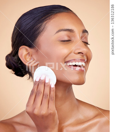 Happy woman, cotton pad and skincare of face cosmetics, aesthetic wellness and studio background. Indian female model, clean beauty and facial cleaning product for makeup removal, dermatology or glow 136312186