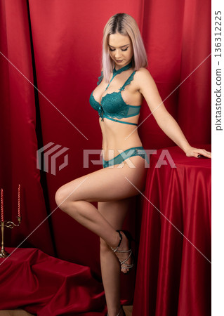 Woman in green lingerie leaning on red table 136312225