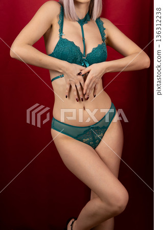 Woman adjusting her green lace bra in studio 136312238
