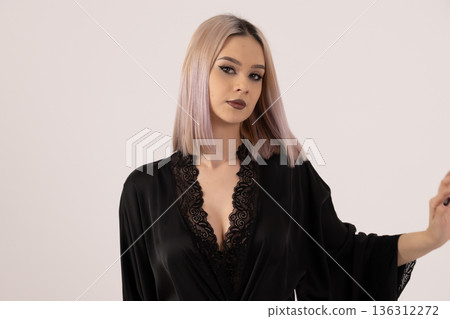 Young woman in black robe posing in white studio Young woman in black robe posing in white studio 136312272