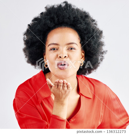 Portrait, happy and black woman blowing a kiss, flirty and seductive against a white studio background. Face, female person or model being alluring, kissing or love with romantic gesture or happiness 136312273
