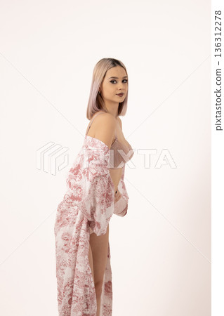 Young woman in light floral robe posing sideways Young woman in light floral robe posing sideways 136312278