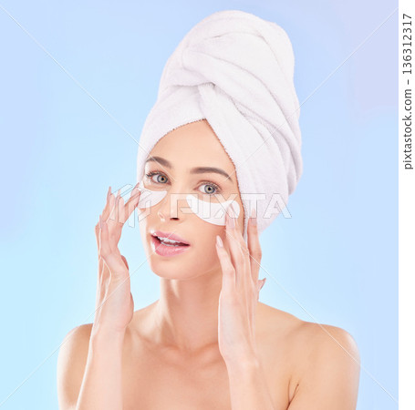 Beauty, eye pads and portrait of woman in studio for natural, health and wellness routine. Skincare, cosmetic and young female model from Australia with a clean skin treatment by a blue background. Beauty, eye pads and portrait of woman in studio for natural, health and wellness routine. Skincare, cosmetic and young female model from Australia with a clean skin treatment by a blue background. 136312317
