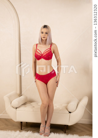 Woman standing in red lingerie on white background 136312320