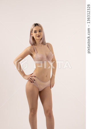 Young woman posing in nude underwear set in studio Young woman posing in nude underwear set in studio 136312326