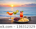 Sunset over the sea, cocktails and snacks 136312329