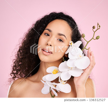 Face, orchid and skincare of woman for beauty in studio isolated on a pink background. Portrait, flowers and model with plant, floral cosmetic or natural organic treatment for healthy skin aesthetic Face, orchid and skincare of woman for beauty in studio isolated on a pink background. Portrait, flowers and model with plant, floral cosmetic or natural organic treatment for healthy skin aesthetic 136312527