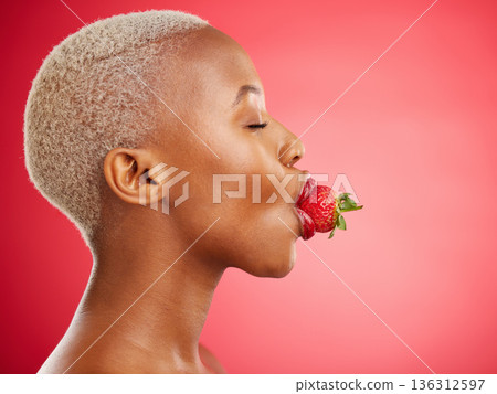 Woman, strawberry and studio for beauty, profile and skincare for wellness, health and diet by red background. African model girl, healthy fruit and mouth with eyes closed, nutrition and cosmetics 136312597
