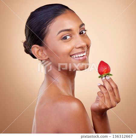Portrait, woman with a strawberry and skincare with natural beauty in studio or benefits in healthy nutrition, diet or fruit. Girl, eating or food with vitamin c for skin to glow or wellness of body 136312667