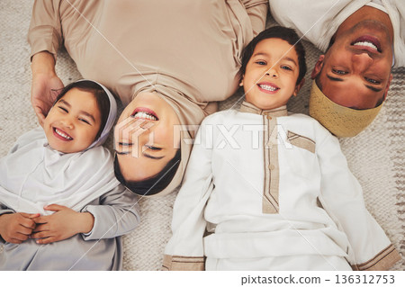 Portrait smile, floor and muslim family of mother, father and children smile, love or enjoy quality time together. Lounge top view, care and happy face of Islamic mom, young kids or dad relax at home 136312753