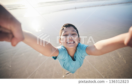 Person, spin kid and pov at beach, portrait and smile for game, excited and playing by water in sunshine. Parent, young boy child and swing with speed, love and bonding with holding hands by ocean 136312823
