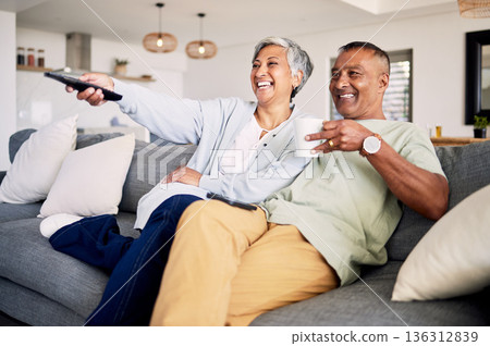 Senior couple, watching tv and relax on sofa in home living room, laughing and together for funny comedy show. Elderly man, old woman and happy for streaming comic movie on lounge couch in house Senior couple, watching tv and relax on sofa in home living room, laughing and together for funny comedy show. Elderly man, old woman and happy for streaming comic movie on lounge couch in house 136312839