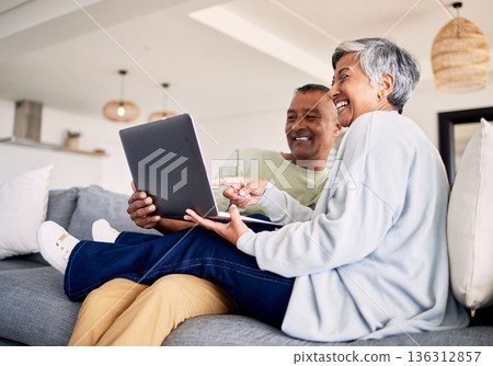 Mature couple, laptop and relax on sofa in living room, download media and choice of watching movie together. Happy man, woman and computer for streaming online video, web subscription and internet Mature couple, laptop and relax on sofa in living room, download media and choice of watching movie together. Happy man, woman and computer for streaming online video, web subscription and internet 136312857