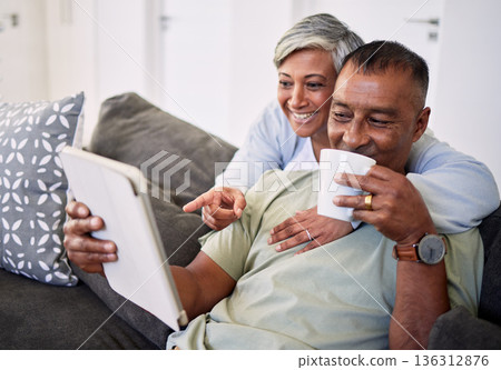 Home, tablet and happy senior couple on sofa, relax and check email, news article and point at online shopping choice. Website info, decision or elderly man, old woman or people smile in living room 136312876