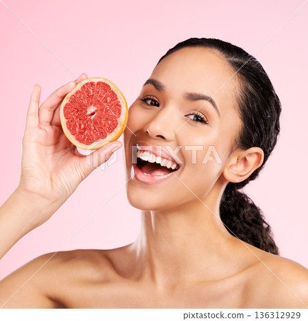 Grapefruit, beauty and face of happy woman with skin care, dermatology or natural glow. Portrait of a female model with fruit for vitamin c, cosmetics or healthy diet for detox on studio background Grapefruit, beauty and face of happy woman with skin care, dermatology or natural glow. Portrait of a female model with fruit for vitamin c, cosmetics or healthy diet for detox on studio background 136312929
