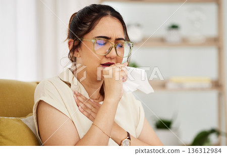 Coughing, tissue and sick woman on a sofa with cold, flu or sore throat in her home. Allergies, influenza and female with viral infection, bacteria and covid risk in a living room with tuberculosis Coughing, tissue and sick woman on a sofa with cold, flu or sore throat in her home. Allergies, influenza and female with viral infection, bacteria and covid risk in a living room with tuberculosis 136312984