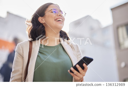 Phone, walking and happy woman outdoor in a city with communication, internet connection and app. Laugh, professional person and urban road with smartphone for message, chat or social media on travel 136312989