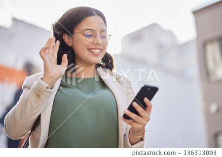 Business, woman and phone with video call in the city and contact with network connection, communication or conversation. Happy, wave and person speaking on mobile or hello, gesture and greeting Business, woman and phone with video call in the city and contact with network connection, communication or conversation. Happy, wave and person speaking on mobile or hello, gesture and greeting 136313003