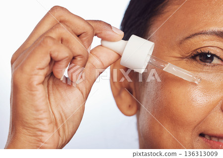 Woman, portrait or oil serum on face, aesthetic skincare or dermatology on studio background. Closeup of mature model, facial cosmetic product or dropper of hyaluronic acid, liquid collagen or beauty Woman, portrait or oil serum on face, aesthetic skincare or dermatology on studio background. Closeup of mature model, facial cosmetic product or dropper of hyaluronic acid, liquid collagen or beauty 136313009