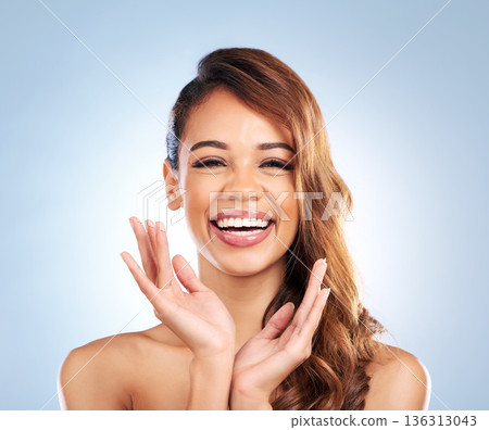 Portrait, hair care or happy woman laughing with beauty, wellness or skincare in studio on blue background. Natural hairstyle, funny girl or confident model proud of facial for healthy glowing skin 136313043