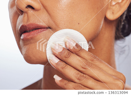 Beauty, closeup or woman with cotton pad for dermatology, wellness or facial skincare routine in studio. White background, hand or face of lady cleaning with swab for glow, cleansing or dirt removal Beauty, closeup or woman with cotton pad for dermatology, wellness or facial skincare routine in studio. White background, hand or face of lady cleaning with swab for glow, cleansing or dirt removal 136313094