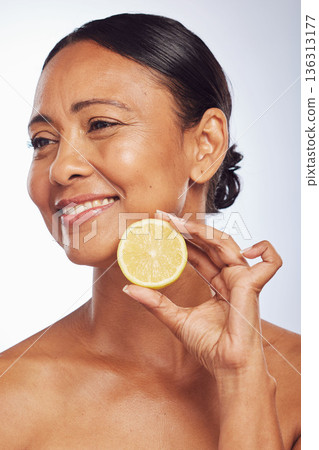 Thinking, orange and senior woman with skincare, dermatology and treatment against a white studio background. Mature female person, happy lady or model with citrus fruit, natural beauty and vitamin c 136313177