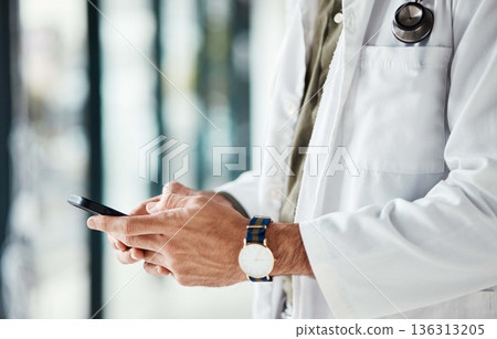 Phone, hands and man doctor typing message, social media or planning online schedule in a hospital. Telehealth, search and male healthcare expert with smartphone for advice, chat or research check 136313205