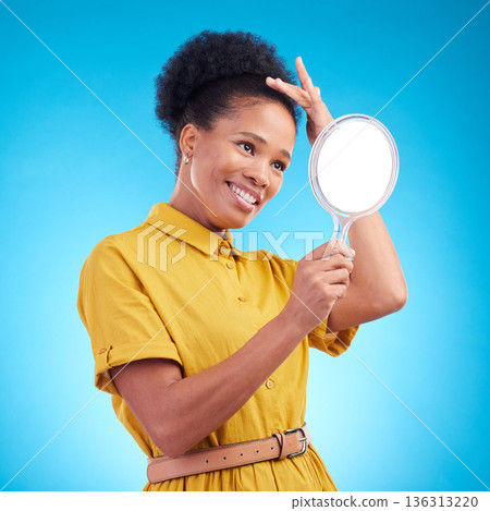 Happy, beauty and a woman with a mirror in studio for hair care, confidence and appearance. Fashion, makeup and cosmetics of African female model person in casual style clothes on a blue background Happy, beauty and a woman with a mirror in studio for hair care, confidence and appearance. Fashion, makeup and cosmetics of African female model person in casual style clothes on a blue background 136313220
