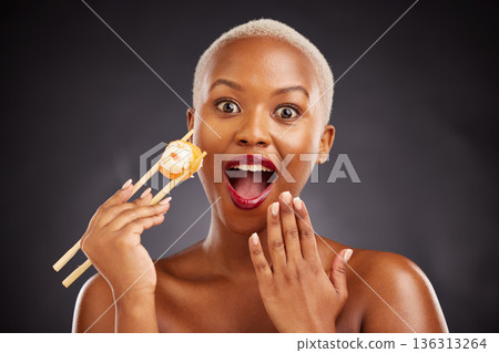 Face, surprise and woman with sushi and chopsticks in studio for healthy eating, beauty or food. Black female model with makeup on dark background for wellness glow, wow diet or seafood portrait Face, surprise and woman with sushi and chopsticks in studio for healthy eating, beauty or food. Black female model with makeup on dark background for wellness glow, wow diet or seafood portrait 136313264