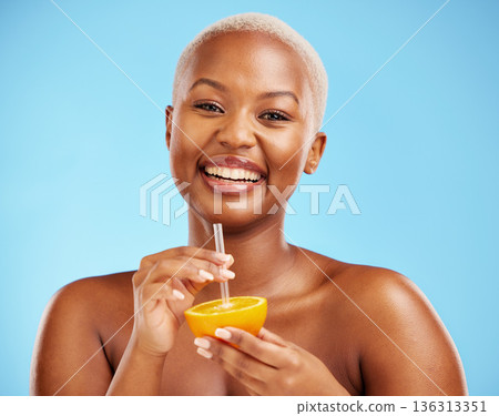 Happy black woman, portrait and orange for vitamin C, diet or natural nutrition against a blue studio background. African female person smile with citrus fruit and straw for healthy wellness or juice 136313351