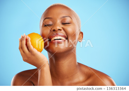 Orange, funny and black woman with skincare, dermatology or cosmetics on a blue studio background. Female person, humor or model with citrus fruit, health or wellness with vitamin c or natural beauty Orange, funny and black woman with skincare, dermatology or cosmetics on a blue studio background. Female person, humor or model with citrus fruit, health or wellness with vitamin c or natural beauty 136313364