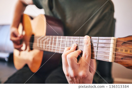 Hands, person and guitar for music, talent and skills in home studio. Closeup, musician and singer playing acoustic instrument for audio performance, artist and learning notes for sound production Hands, person and guitar for music, talent and skills in home studio. Closeup, musician and singer playing acoustic instrument for audio performance, artist and learning notes for sound production 136313384