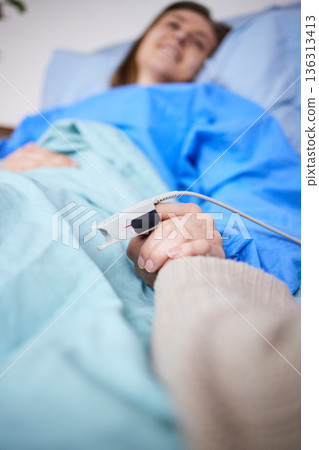 Holding hands, support and woman in hospital for cancer, sick or surgery. Comfort, care and person together with patient for hope, empathy or kindness, health and faith to help with medical healing. 136313413