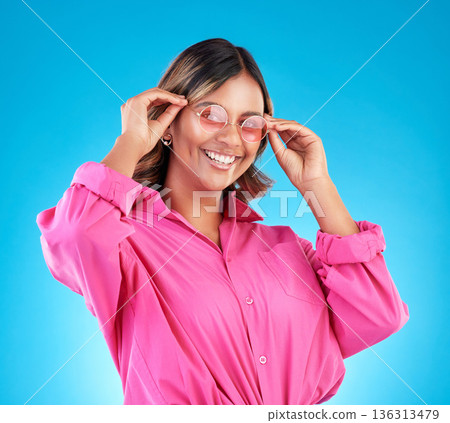 Fashion sunglasses, portrait and happy woman in studio isolated on a blue background. Face, glasses and Indian model with style, designer shades and positive mindset for aesthetic, gen z and smile Fashion sunglasses, portrait and happy woman in studio isolated on a blue background. Face, glasses and Indian model with style, designer shades and positive mindset for aesthetic, gen z and smile 136313479