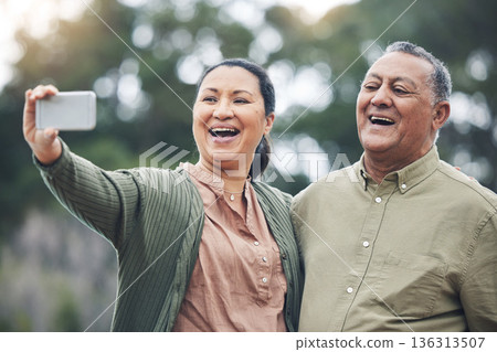 Happy senior couple, selfie and laughing for photo, picture or memory together in nature outdoors. Elderly man and woman smile for social media, online post or vlog in happiness for capture outside Happy senior couple, selfie and laughing for photo, picture or memory together in nature outdoors. Elderly man and woman smile for social media, online post or vlog in happiness for capture outside 136313507
