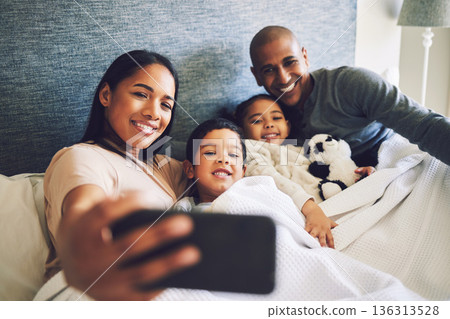 Parents, children or family selfie in a bed together with love, care and security or comfort. Woman, man and kids with a happy smile for quality time or profile picture in a home bedroom to relax 136313528