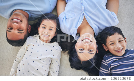 Above, portrait and happy family on a floor relax, bond and playing in their home on the weekend. Face, smile and top view of children with young parents in a bedroom with love, fun and chilling Above, portrait and happy family on a floor relax, bond and playing in their home on the weekend. Face, smile and top view of children with young parents in a bedroom with love, fun and chilling 136313678
