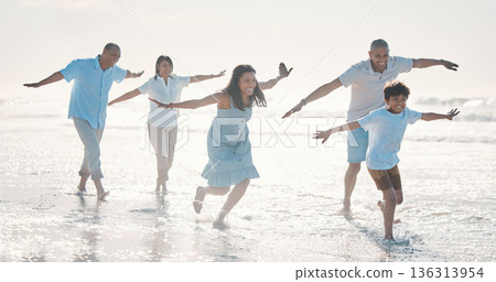 Travel, beach and happy family running together at the sea or ocean bonding for love, care and happiness. Summer, sun and parents with children or kids and grandparents on a holiday for freedom 136313954