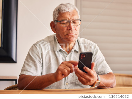Phone, social media and a senior man in his home, reading or typing a text message for communication. Mobile, contact and chatting with an elderly male pensioner sitting in his house for networking Phone, social media and a senior man in his home, reading or typing a text message for communication. Mobile, contact and chatting with an elderly male pensioner sitting in his house for networking 136314022