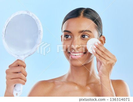 Mirror, cotton and woman with beauty or skincare as cosmetic product treatment isolated in a studio blue background. Cleaning pad, exfoliate and young female person with clean face due to facial 136314071
