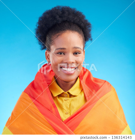 Pride, flag and portrait of black woman in studio for gay, rights and lgbtq lifestyle on blue background. Rainbow, freedom and face of lesbian African female happy, smile and confident with sexuality 136314143
