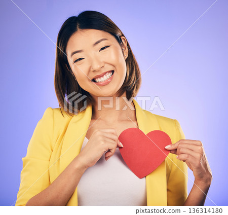 Support, asian girl and care with paper heart with portrait in purple studio or background with emotion. Woman, happy and face with love sign for peace or kindness with emoji shape for hope or smile. 136314180