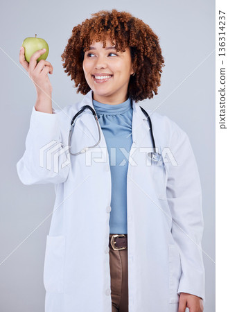 Doctor, woman and smile with apple in white background, studio and vitamin c wellness. Happy female medical worker, nutritionist and advice of green fruits for nutrition, healthy food and detox diet Doctor, woman and smile with apple in white background, studio and vitamin c wellness. Happy female medical worker, nutritionist and advice of green fruits for nutrition, healthy food and detox diet 136314237