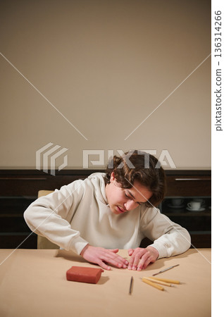 Young Boy Molding Clay at Home, Focused on Creative Hobby and Craft Activity During Free Time Young Boy Molding Clay at Home, Focused on Creative Hobby and Craft Activity During Free Time 136314266