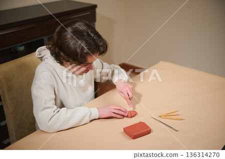 Young Boy Molding Clay At Home, Focused On Crafting With Tools And Clay Block Project 136314270