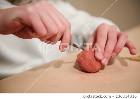 Hands At Work: Clay Sculpting With Pink Clay Ball and Tool in Home Craft Session 136314316