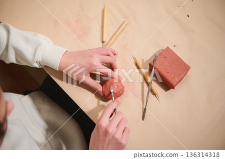 Young Artist At Home Molding Clay With Tools, Creating Sculptures In A Hobby Studio Young Artist At Home Molding Clay With Tools, Creating Sculptures In A Hobby Studio 136314318