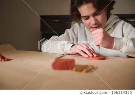 Young Boy Sculpting With Clay At Home Using Tools For Hobby Project Young Boy Sculpting With Clay At Home Using Tools For Hobby Project 136314330